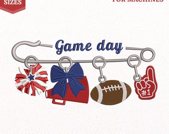 Op de afbeelding: Een borduurontwerp voor machines met een grote veiligheidsspeld en de tekst Game day. Aan de speld hangen een rood-wit-blauwe pompon, een rode megafoon met een blauwe strik, een bruine football en een rode schuimvinger met de tekst #1.