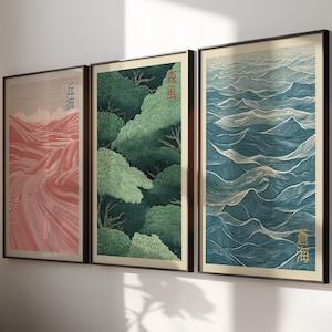 以下が含まれることがあります： 日本の風景デザインの3つの額入りアートプリント。赤い山の風景、緑の森、青い海の波が特徴です。各プリントは黒いフレームに入っており、まとまりのあるウォールアートセットになっています。