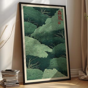Könnte beinhalten: Ein gerahmter vertikaler Wandkunstdruck, der eine dichte Waldszene mit geschichteten grünen Baumkronen und sichtbaren Ästen zeigt. Das Kunstwerk enthält rote japanische Kanji-Zeichen in der oberen rechten Ecke, eingefasst in einen dünnen schwarzen Rahmen.