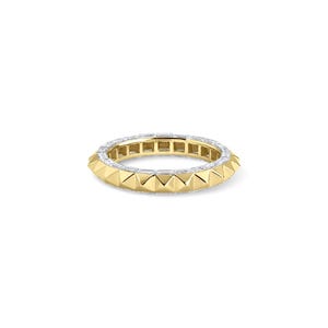 May include: A gold ring with a band of white gemstones and a row of gold pyramid-shaped studs. The ring is set against a white background.