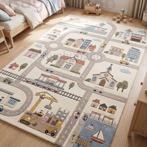 May include: A rectangular area rug featuring a colorful city map design with roads, a railway, buildings, a school, a church, a construction site with a crane, and a harbor with boats. The rug has a cream background with pastel-colored illustrations.
