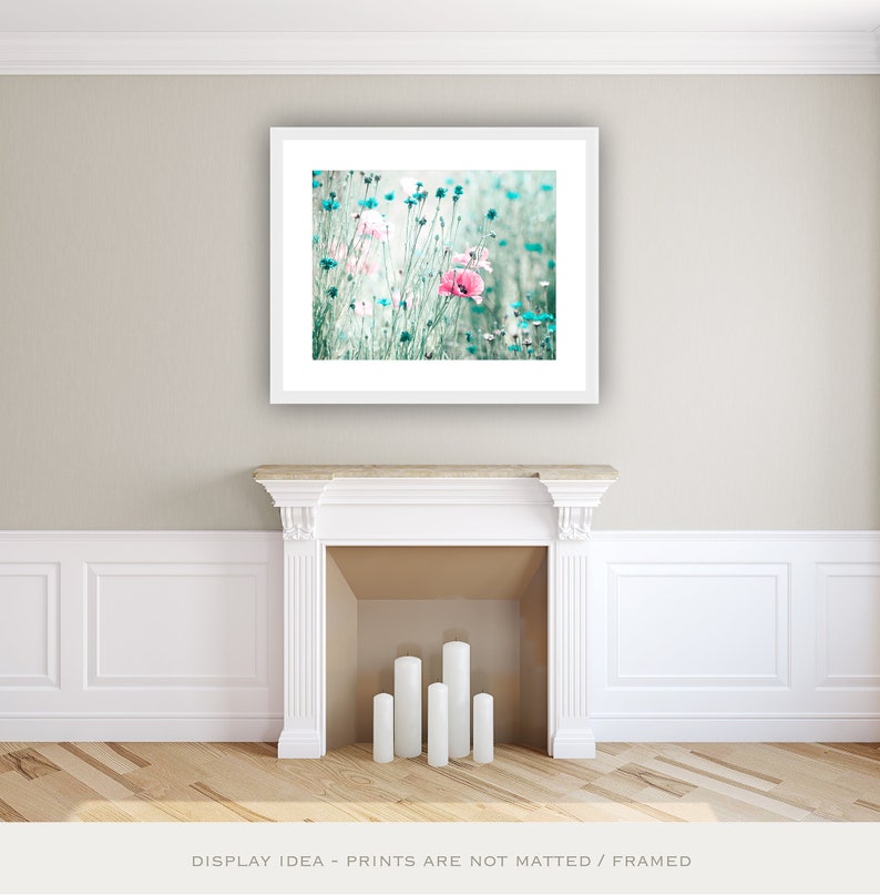 Pode incluir: Uma impress&atilde;o floral emoldurada com flores rosa e azuis em um campo. A obra de arte &eacute; exibida acima de uma lareira branca com velas. O texto na parte inferior diz "DISPLAY IDEA - PRINTS ARE NOT MATTED / FRAMED."