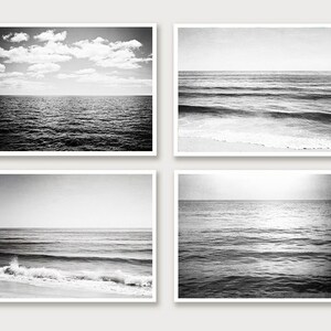 Puede incluir: Conjunto de cuatro impresiones de paisajes marinos en blanco y negro. Las impresiones representan varias escenas oce&aacute;nicas, incluyendo olas, el horizonte y un cielo nublado. Cada impresi&oacute;n est&aacute; enmarcada en un cuadrado blanco.