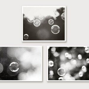 May include: Three framed monochrome photographs. The top image depicts bubbles floating. The bottom left image shows a single bubble. The bottom right image shows multiple bubbles, all in soft focus.