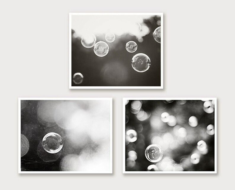 May include: Three framed monochrome photographs. The top image depicts bubbles floating. The bottom left image shows a single bubble. The bottom right image shows multiple bubbles, all in soft focus.