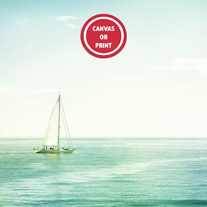May include: A serene seascape featuring a sailboat gliding across turquoise waters under a pale blue sky. A red circular graphic with the text "CANVAS OR PRINT" is in the upper center. The image evokes a sense of tranquility and nautical themes.