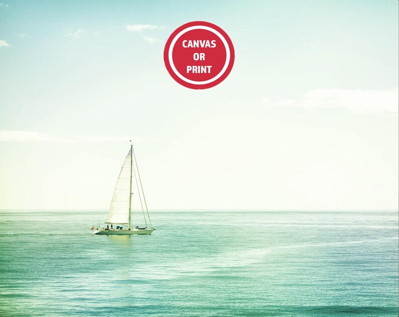May include: A serene seascape featuring a sailboat gliding across turquoise waters under a pale blue sky. A red circular graphic with the text "CANVAS OR PRINT" is in the upper center. The image evokes a sense of tranquility and nautical themes.