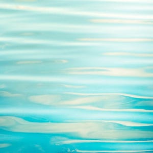 Puede incluir: Imagen abstracta de agua con un degradado de tonos azules y turquesas. La superficie del agua tiene suaves ondulaciones y reflejos, creando una sensaci&oacute;n de profundidad y movimiento. El efecto general es sereno y calmante.