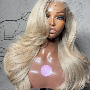 Könnte beinhalten: Eine weiße Keramik-Tasse mit schwarzem Henkel und dem Text "But First, Coffee" in fetter, schwarzer Schrift. Die Tasse steht vor einem neutralen Hintergrund, der ihr schlichtes Design hervorhebt.