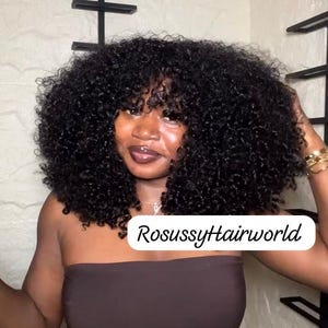 Puede incluir: Una persona con cabello rizado oscuro y flequillo. Lleva un top sin tirantes marrón y vaqueros azules. El texto "RosussyHairworld" aparece en la imagen.