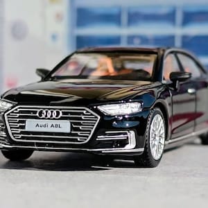 May include: A set of three ceramic mugs with a speckled, matte finish in cream, light grey, and dark grey. Each mug has a simple, minimalist design and a rounded handle.