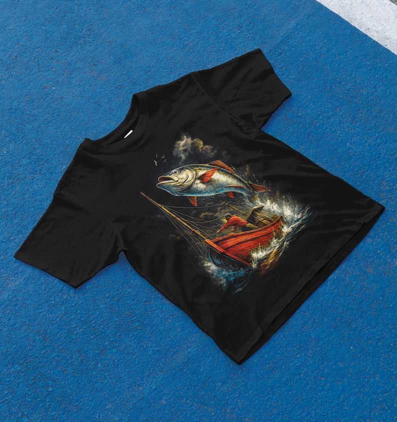 K&ouml;nnte beinhalten: Schwarzes T-Shirt mit einer detaillierten Illustration eines Fisches, der aus dem Wasser springt, in der N&auml;he eines roten Bootes mit einer Person darin. Das Kunstwerk hat ein Vintage-Nautik-Thema mit Fokus auf Angeln und Meer.