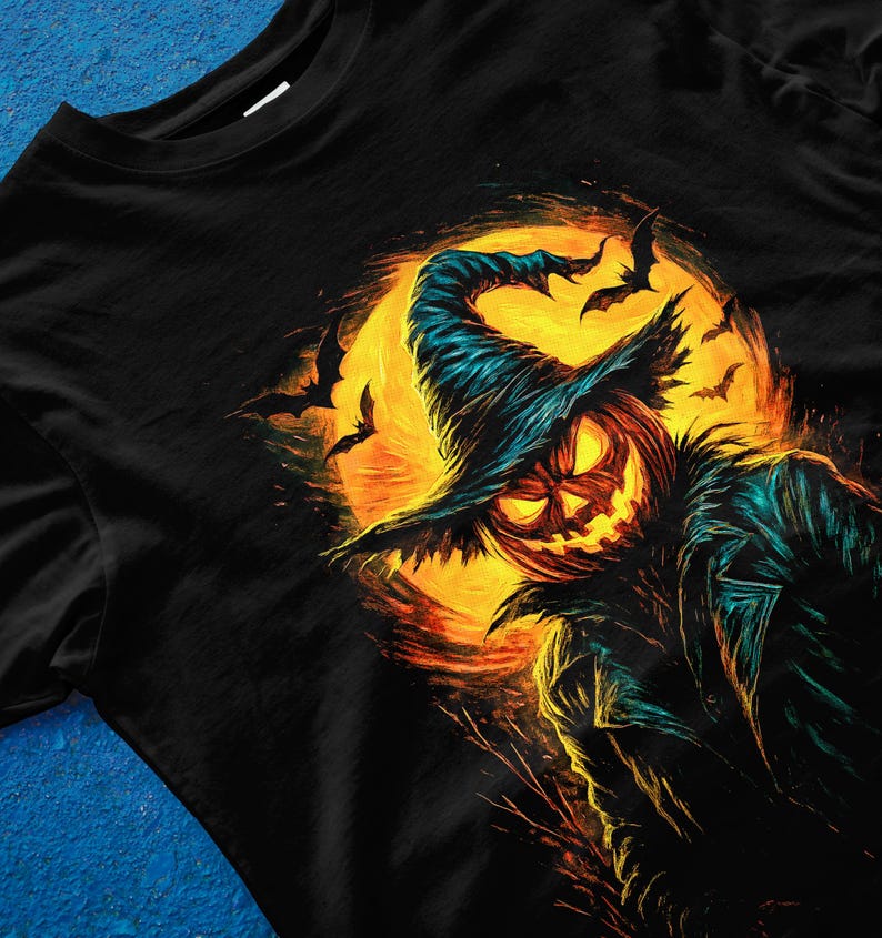 Pu&ograve; includere: T-shirt nero con un'illustrazione a tema Halloween. Il design presenta una zucca con un cappello da strega sullo sfondo di una luna piena e pipistrelli. L'opera d'arte utilizza una vivace tavolozza di colori arancione, giallo e verde acqua.