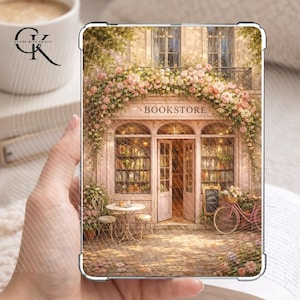 Könnte beinhalten: Eine transparente Schutzhülle mit einer malerischen Buchhandlungsszene. Das Bild zeigt ein malerisches Geschäft mit einem floralen Torbogen, einem rosa Fahrrad und dem Wort "BOOKSTORE" über dem Eingang. Die Hülle wird in einer Hand gehalten.