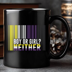 Puede incluir: Taza de cerámica negra con asa. La taza presenta un diseño de código de barras en amarillo, blanco y morado, con el texto "BOY OR GIRL? NEITHER" en blanco y morado. La taza está colocada sobre un fondo con libros y objetos decorativos.