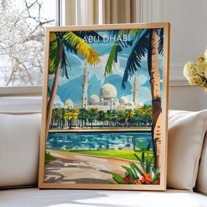 Könnte beinhalten: Gerahmter Kunstdruck mit einer Illustration von Abu Dhabi, Vereinigte Arabische Emirate. Das Kunstwerk zeigt eine große Moschee mit weißen Kuppeln und Minaretten, Palmen und einem Gewässer. Der Druck ist in einem hellen Holzrahmen.