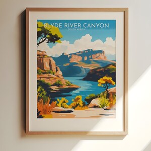 Könnte beinhalten: Gerahmter Kunstdruck mit einer Landschaft des Blyde River Canyon in Südafrika. Das Kunstwerk zeigt einen Fluss, der sich durch einen Canyon schlängelt, mit blauem Wasser, orangefarbenen Felsformationen und grüner und gelber Vegetation. Der Text "BLYDE RIVER CANYON SOUTH AFRICA" steht oben.
