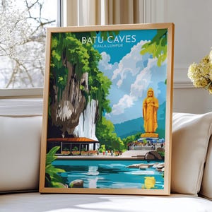 May include: A framed art print featuring the Batu Caves in Kuala Lumpur. The artwork depicts a golden statue, lush greenery, and a serene blue lake. The text "BATU CAVES KUALA LUMPUR" is displayed at the top of the print.