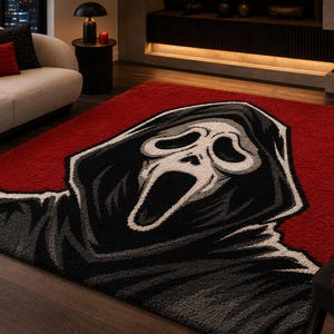Può includere: Un tappeto rettangolare con una grande grafica centrale di una figura incappucciata con una maschera bianca allungata e una bocca spalancata. Il design utilizza una tavolozza di colori rosso intenso, nero, bianco e sfumature di grigio.