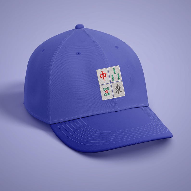 May include: A royal blue baseball cap featuring a four-tile design, reminiscent of a Mahjong game. The tiles are white with red, green, and black symbols. The cap has a curved brim and a button on top.