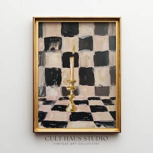 Könnte beinhalten: Gerahmtes Gemälde mit einem goldenen Kerzenhalter mit einer brennenden Kerze. Das Kunstwerk hat ein Schachbrettmuster in Schwarz, Weiß und Rosa. Der Rahmen ist goldfarben, und der Text "CULT HAUS STUDIO VINTAGE ART COLLECTIVE" befindet sich unten.