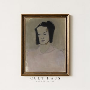 May include: A framed vintage portrait painting of a woman with dark hair and a light-colored blouse. The artwork is in a gold-colored frame and features the text "CULT HAUS ART COLLECTIVE" at the bottom.