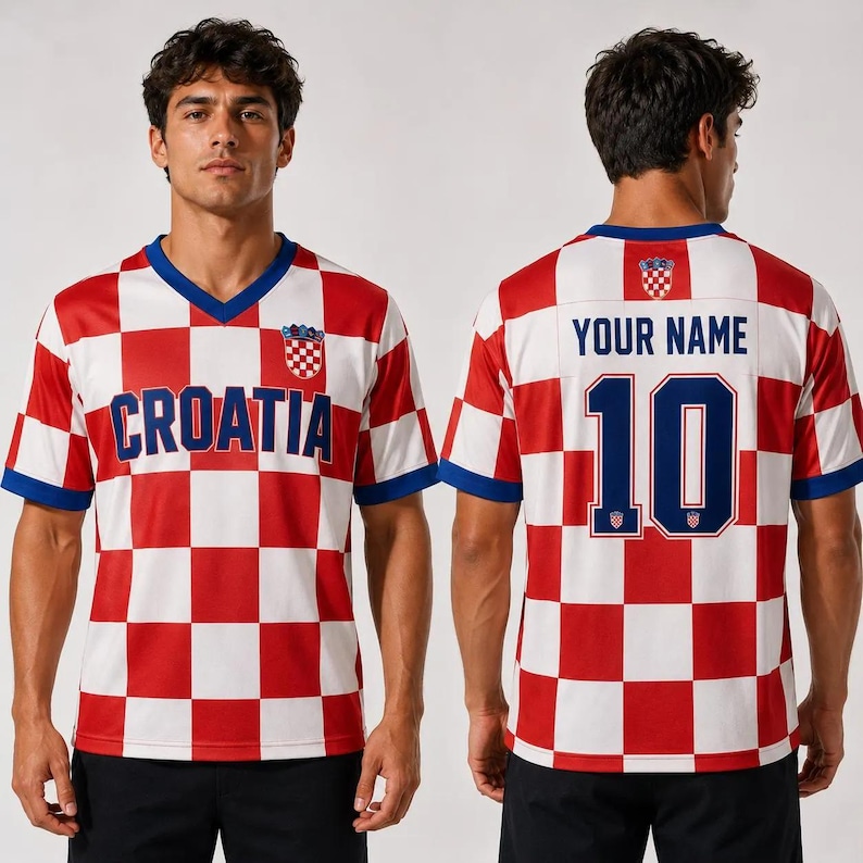 Puede incluir: Una camiseta de manga corta con cuello en V y un patr&oacute;n de cuadros rojos y blancos. El frente muestra el texto "CROATIA" en azul con un peque&ntilde;o escudo. La parte posterior muestra el texto "YOUR NAME" sobre el n&uacute;mero "10" en azul con escudo.