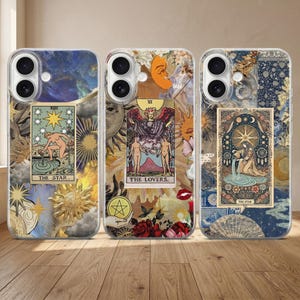 Puede incluir: Tres fundas para teléfono con diseños de cartas del tarot. Las fundas presentan imágenes de las cartas "The Star" y "The Lovers", junto con elementos celestiales y florales. Las fundas tienen un diseño transparente y protector, mostrando la obra de arte.