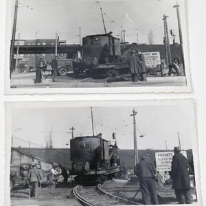 May include: Two vintage black and white photographs. The primary image shows a small, boxy train car on tracks, with several people standing around it. A sign reads "Private". A truck and building are in the background.