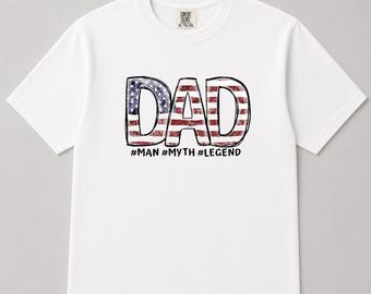 May include: White t-shirt with the word "DAD" in large, distressed letters filled with an American flag design. Below the word "DAD" are the hashtags: #MAN #MYTH #LEGEND. The shirt is a Comfort Colors XL-TG-EG.