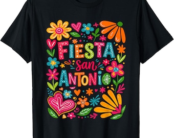 May include: Black t-shirt with a colorful floral design and the words "Fiesta San Antonio" in a vibrant, playful font. The design includes flowers, hearts, and decorative elements in shades of pink, orange, blue, and green.