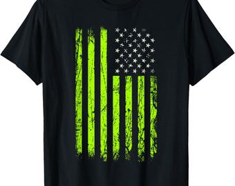 May include: Black t-shirt featuring a distressed American flag design. The flag's stripes are bright neon green, and the stars are white. The design has a worn, vintage look, with a slightly faded appearance.