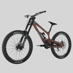 Könnte beinhalten: Ein braunes und schwarzes Mountainbike mit schwarzen Reifen und einem schwarzen Sattel. Das Fahrrad hat eine Federgabel und Scheibenbremsen. Der Rahmen hat blaue Akzente. Auf den Reifen steht das Wort "Maxxis".