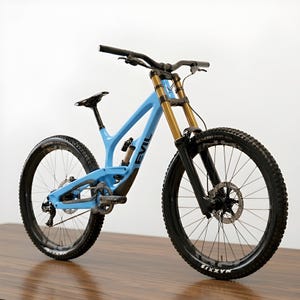 Puede incluir: Bicicleta de montaña azul claro con neumáticos negros y horquillas de suspensión doradas. La bicicleta tiene la palabra "EVIL" impresa en el cuadro. Los neumáticos tienen la marca "MAXXIS".