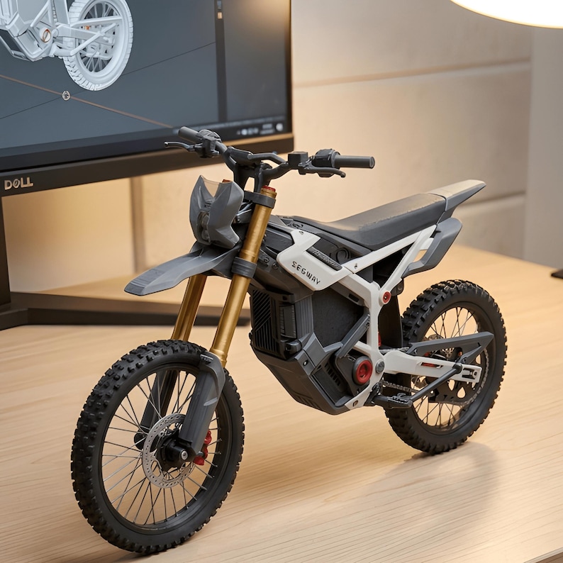 May include: A grey and white Segway dirt bike model with black tyres and gold suspension. The bike has the word "Segway" printed on the side. The bike is on a wooden surface.