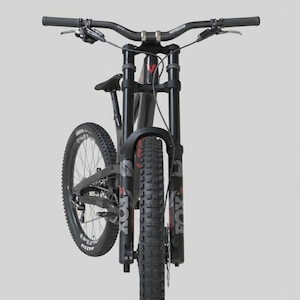 May include: A black mountain bike with a suspension fork and wide handlebars. The tires are thick and knobby, designed for off-road use. The bike has the brand name "FOX" printed on the front suspension.
