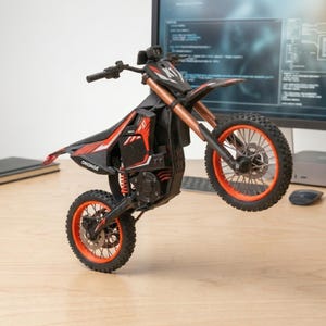 May include: A black and red toy motorcycle with orange accents is captured mid-wheelie. The motorcycle features the text "OHONGE" and "X1". The tires and rims are orange. The motorcycle is on a wooden surface.