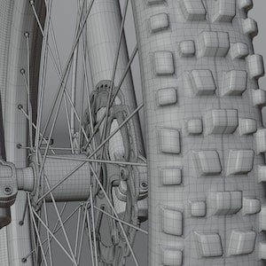 May include: Close-up of a mountain bike wheel, showcasing the tire tread, spokes, and disc brake. The tire has a textured pattern for grip. The wheel's design is detailed, with a focus on the mechanical components.