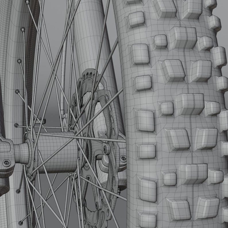 May include: Close-up of a mountain bike wheel, showcasing the tire tread, spokes, and disc brake. The tire has a textured pattern for grip. The wheel's design is detailed, with a focus on the mechanical components.