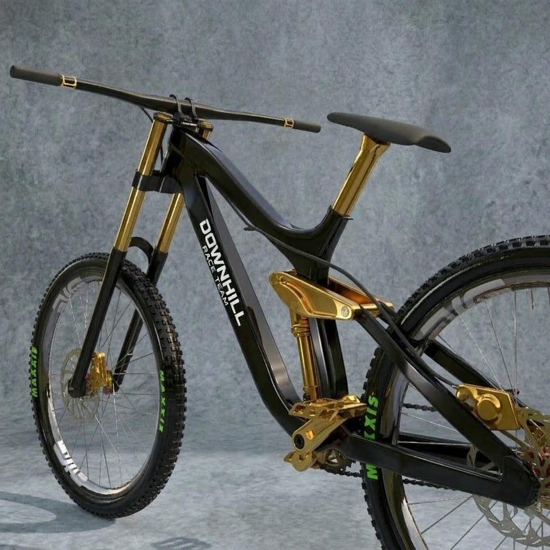 May include: A black and gold downhill mountain bike with the text "DOWNHILL RACE TEAM" on the frame. The bike has gold suspension, handlebars, and accents. The tires have the word "MAXXIS" in green.