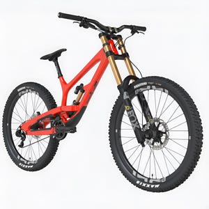 Könnte beinhalten: Ein rotes Mountainbike mit schwarzen Reifen und goldenen Federgabeln. Das Fahrrad hat einen schwarzen Sattel und Lenker. Die Reifen haben weiße Schrift mit der Aufschrift "MAXXIS". Das Fahrrad ist für den Geländeeinsatz konzipiert.