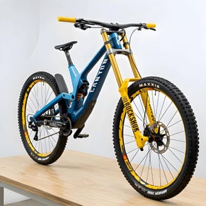 Puede incluir: Una bicicleta de monta&ntilde;a azul y amarilla con neum&aacute;ticos negros. La bicicleta tiene la marca "Canyon" en el cuadro y "Rockshox" en la suspensi&oacute;n delantera. Los neum&aacute;ticos tienen detalles amarillos y la bicicleta est&aacute; sobre una superficie de madera.