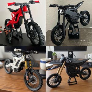 Puede incluir: Cuatro mini motos eléctricas en rojo, negro, blanco y negro con detalles dorados. Cada moto está sobre un soporte, mostrando el diseño del cuadro, las ruedas y el manillar. Las motos están detalladas con características realistas.