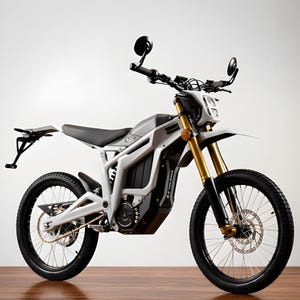 Könnte beinhalten: Ein modernes Elektro-Motorrad mit weiß-grauem Rahmen, schwarzen Reifen und goldenen Federgabeln. Das Motorrad hat ein schlankes Design mit einem schwarzen Sitz, runden Spiegeln und einem Kennzeichenhalter. Das Motorrad steht auf einer Holzoberfläche.