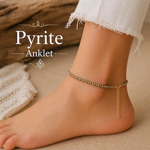 May include: A pyrite anklet featuring small, round, metallic beads. The anklet has a gold-coloured chain. The text "Pyrite Anklet" is displayed in a white, elegant font.