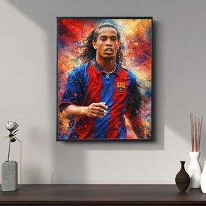 Puede incluir: Una impresión artística enmarcada que presenta un retrato de un futbolista con una camiseta azul y roja. La obra de arte tiene un efecto de acuarela con colores vibrantes de rojo, azul y amarillo. El jugador lleva un collar con la letra "R".