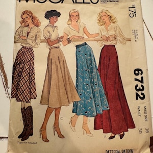 May include: Vintage McCall's sewing pattern envelope. The envelope features illustrations of women wearing skirts and tops. The text on the envelope includes "McCall's", pattern number 6732, and the price.