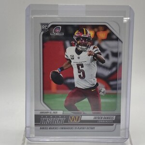 May include: A football trading card featuring Jayden Daniels of the Commanders. The card shows Daniels in his burgundy and gold uniform, holding a football. The card is labelled "Instant" and "Wild Card" with the date January 12, 2025.