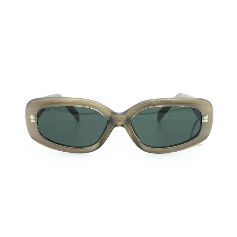 May include: Oval sunglasses with a translucent, taupe-coloured frame and dark lenses. The sunglasses have a rectangular shape and small silver accents on the temples. The lenses are a dark green colour.