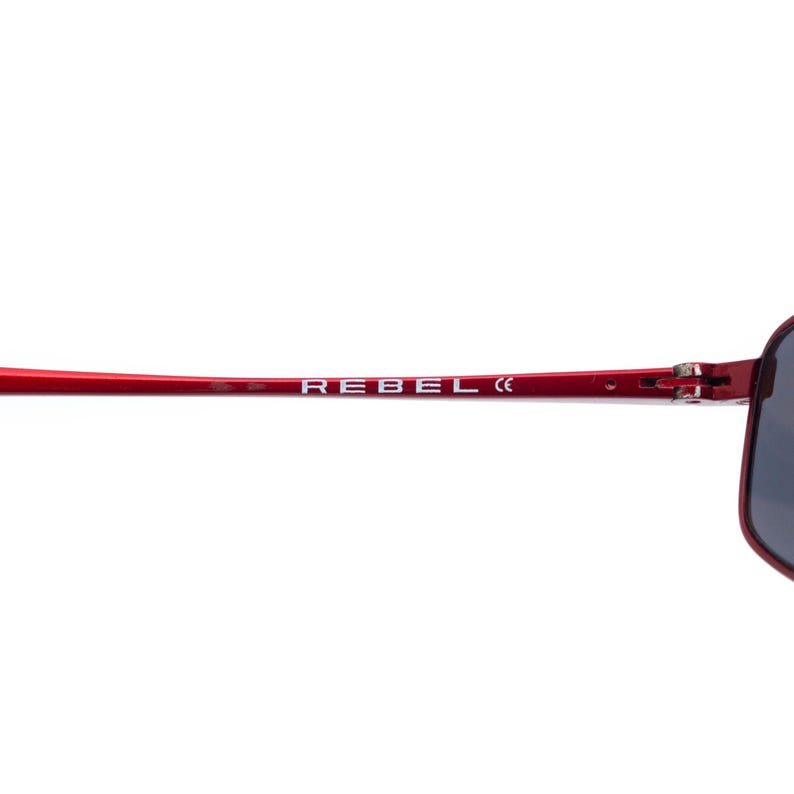 May include: Red sunglasses with the word "REBEL" printed in white on the temple. The sunglasses have a sleek, modern design with dark lenses.